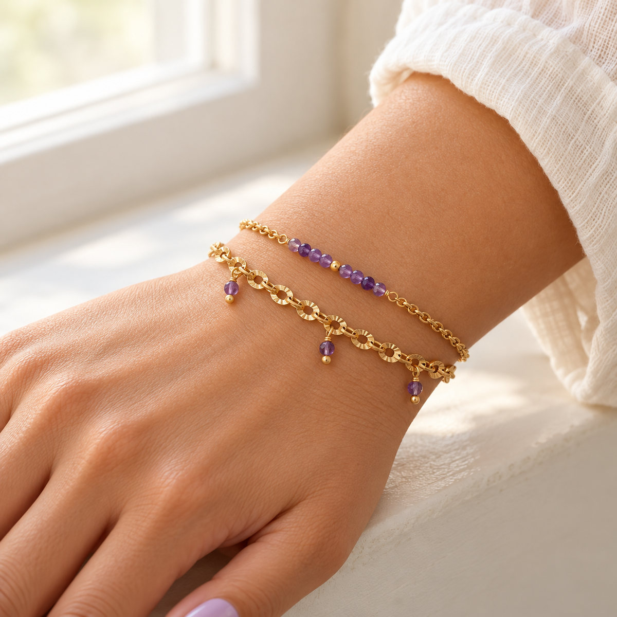 Bracelet Charmeuse en acier inoxydable doré orné d'améthystes, porté au poignet – Gemk